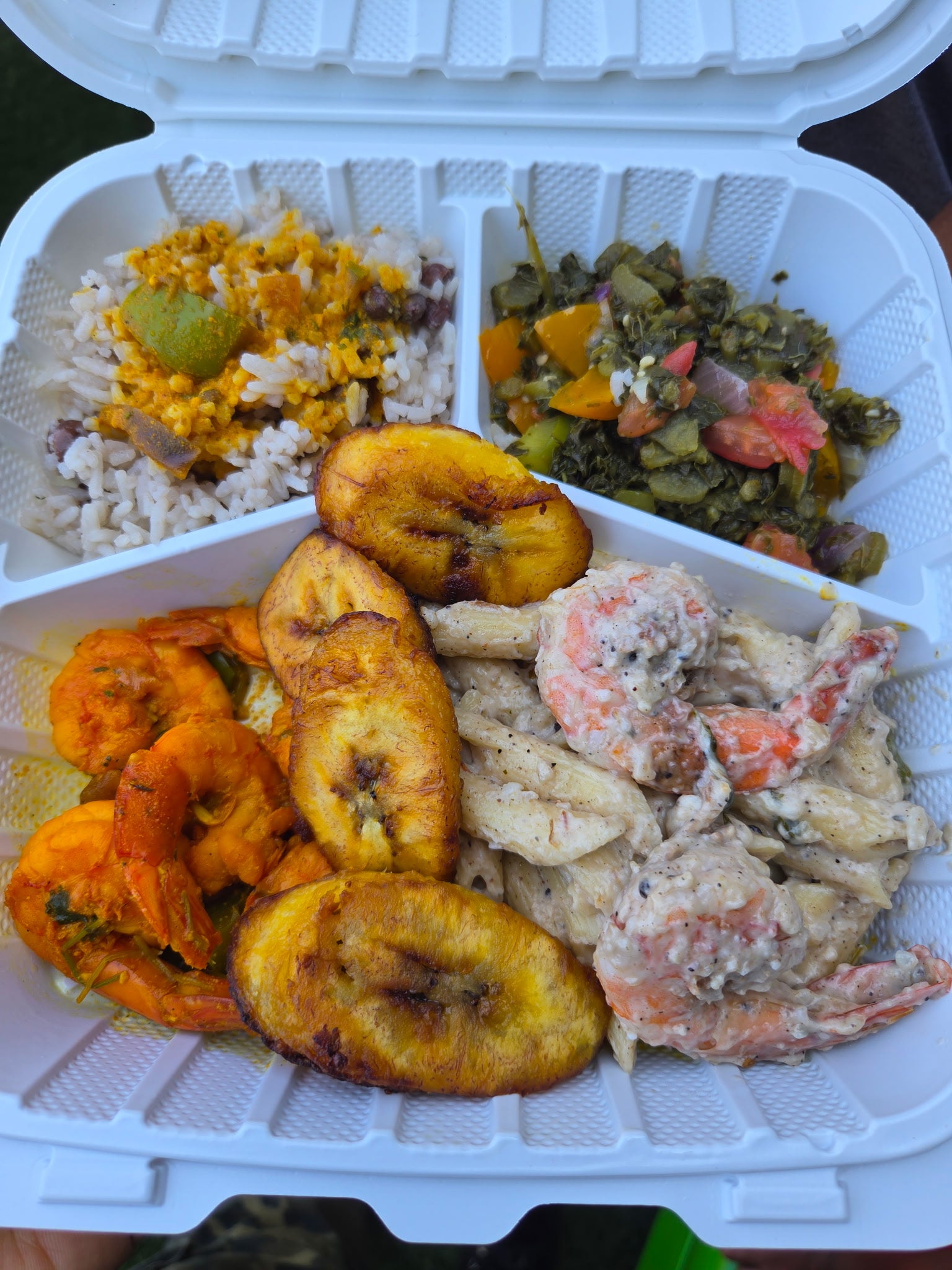 Cultural comfort food plate with stewed shrimp, rice, callaloo, fried plantains and creamy pasta salad