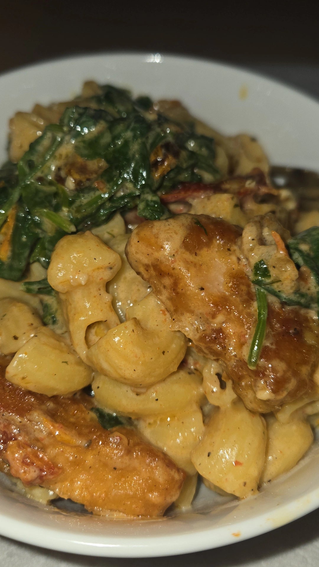 Creamy pasta with fried jackfruit and sautéed spinach and sundried tomatoes